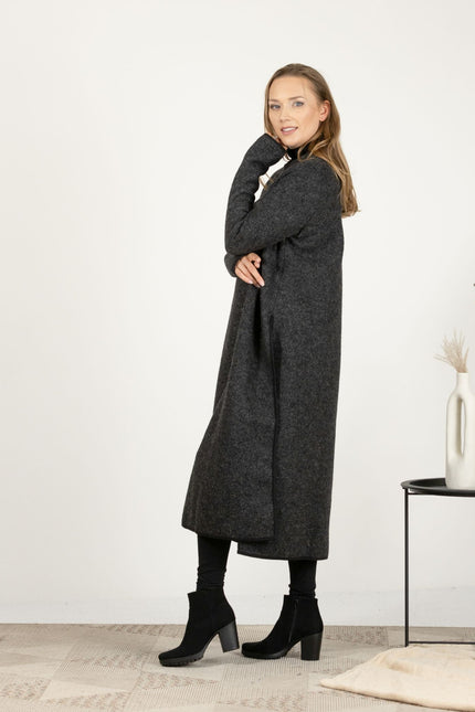 Side view of the Charcoal Wool Winter Sweater Dress, showcasing the relaxed fit and deep side slits that add a modern edge.