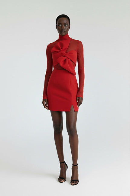 Model wearing a red dress with a bow detail on a white background