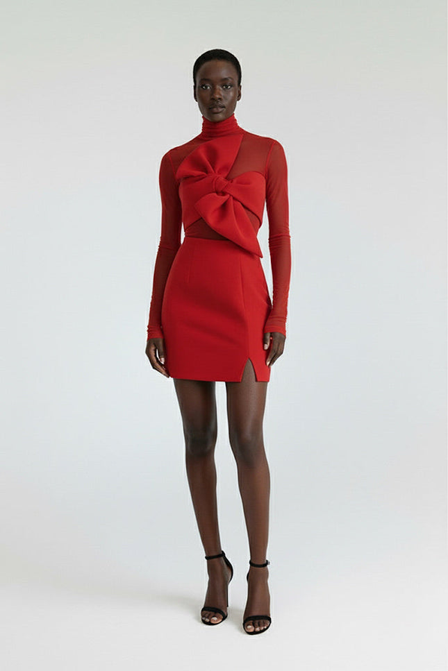 Model wearing a red dress with a bow detail on a white background