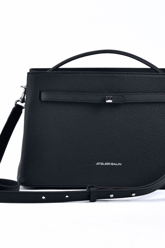 Black atelier galin cube lock handbag with silver hardware and brand logo  handbag with a strap on a white background
