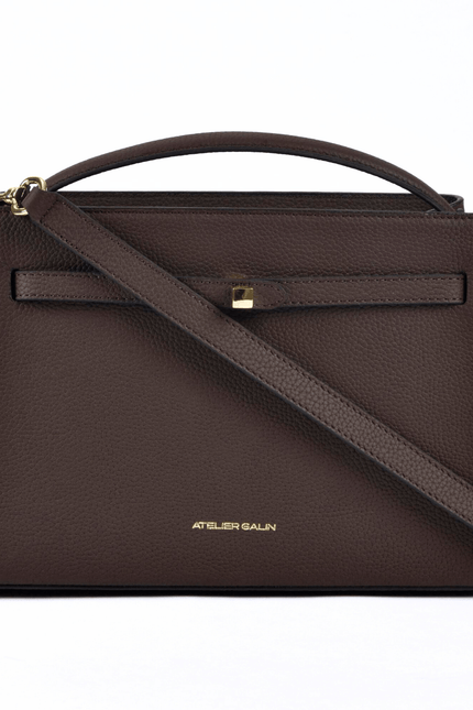 Brown Atelier Galin leather handbag with a shoulder strap on a white background