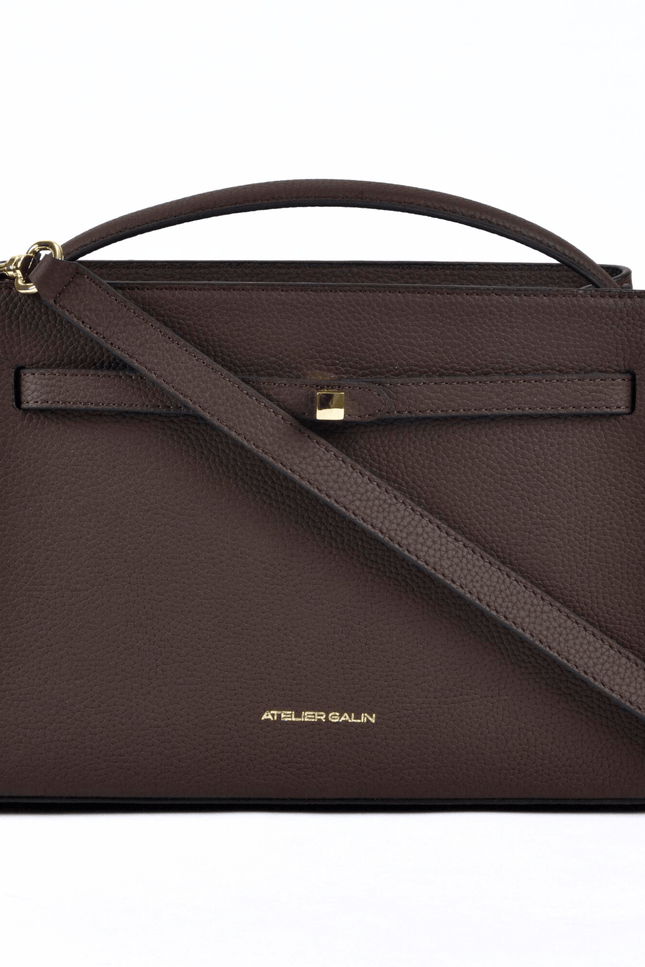 Brown Atelier Galin leather handbag with a shoulder strap on a white background