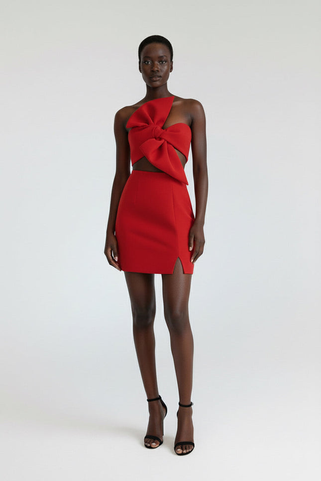 Model wearing a red dress with cut-out design on a white background