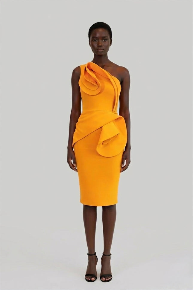 Woman wearing a bright orange dress with a draped design on a gray background