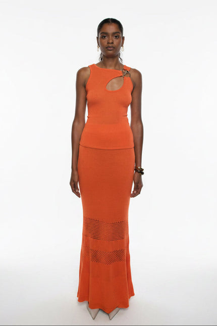 Woman wearing an orange dress with cut-out design on a white background