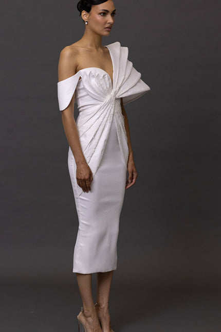 Woman wearing a white off-shoulder dress against a dark background