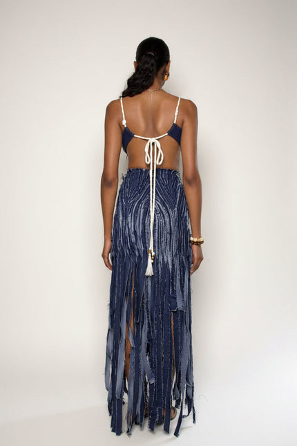 Woman wearing a blue fringe dress with a white background