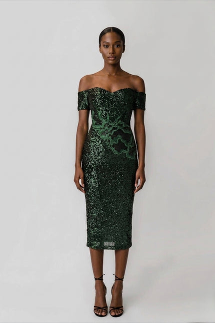 Woman wearing a green sequin off-shoulder dress on a white background