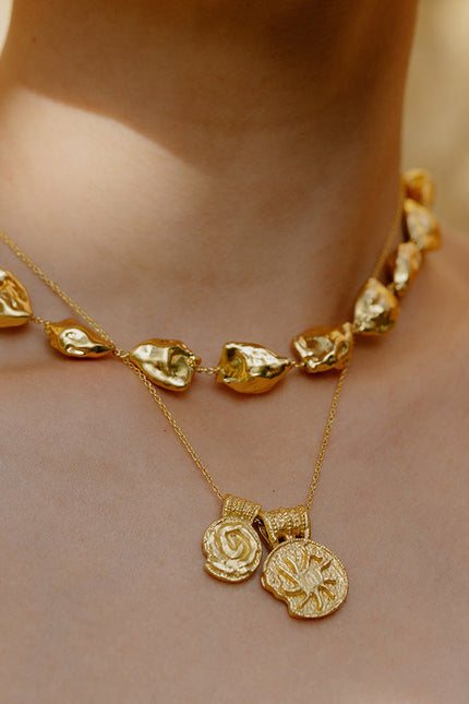 Close up image of person neck wearing Ancient Symbols Charm Necklace by arvino