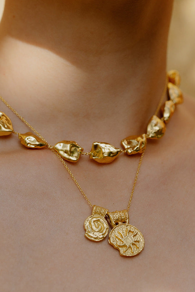 Close up image of person neck wearing Ancient Symbols Charm Necklace by arvino