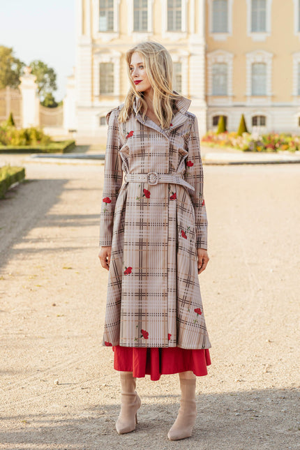 Woman wearing a plaid coat with red accents in an outdoor setting