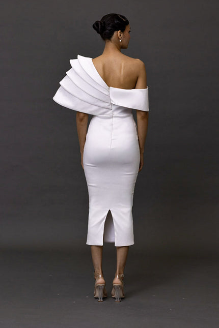 White one-shoulder dress with ruffled detailing on a dark background