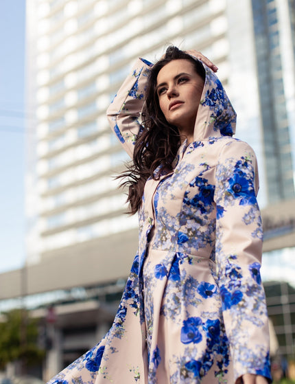 Model wearing Cornflower Blue floral coat – feminine fit-and-flare silhouette with snap button closure