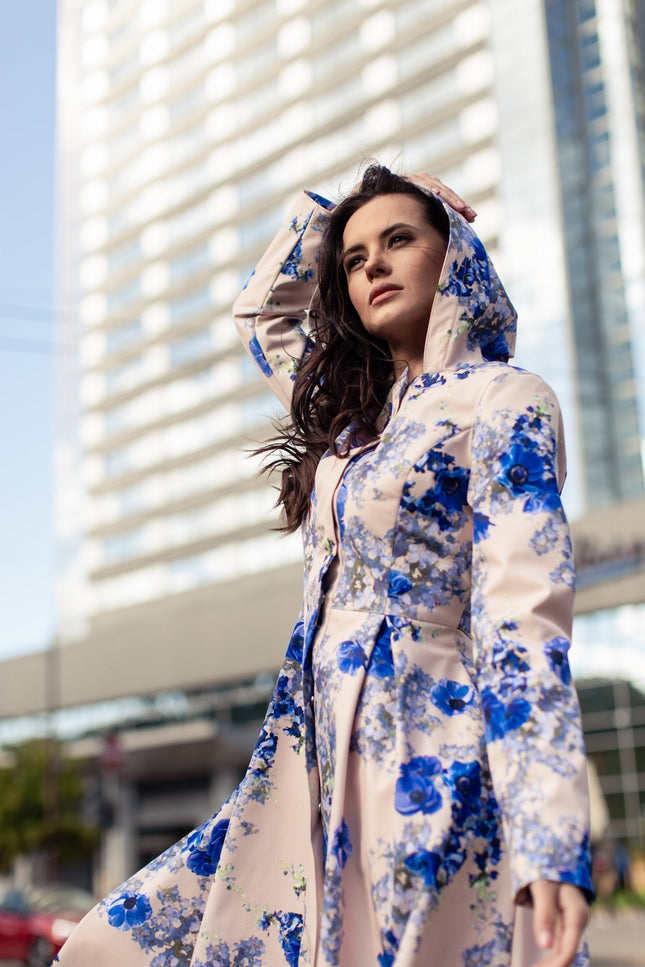 Model wearing Cornflower Blue floral coat – feminine fit-and-flare silhouette with snap button closure