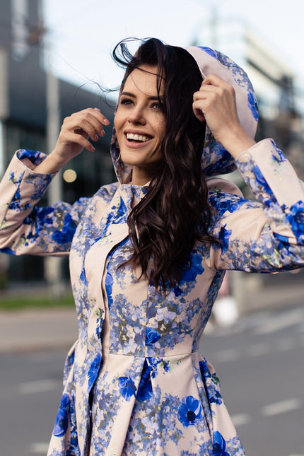 Close-up of blue flower print on Cornflower Blue coat – delicate blooms on beige waterproof fabric