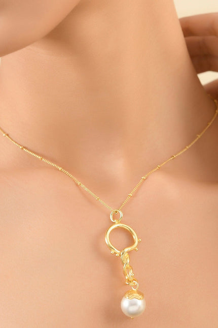 A model wearing a Dewy Pearl Twist 92.5 Sterling Silver Necklace with a luminous baroque pearl suspended from a delicate satellite chain with dewdrop accents and beaded detailing.
