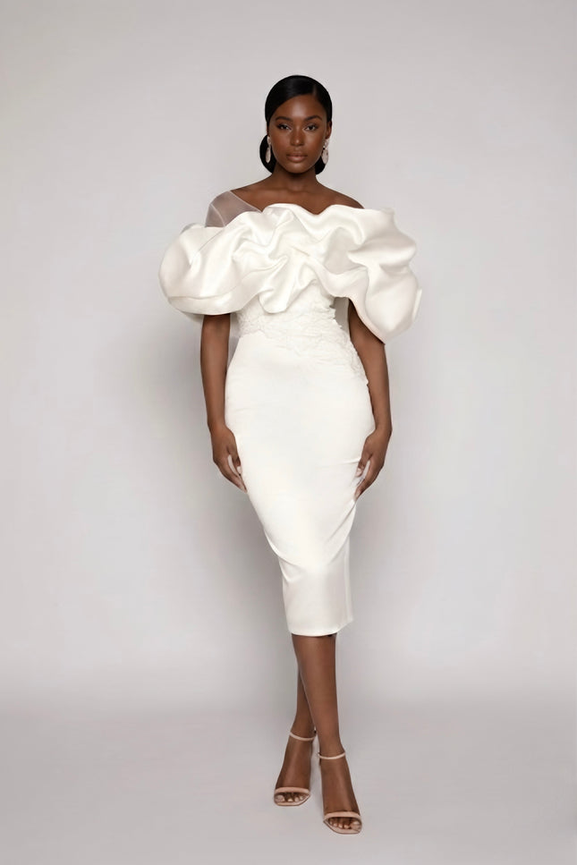 Woman wearing a white dress with large puff sleeves against a gray background