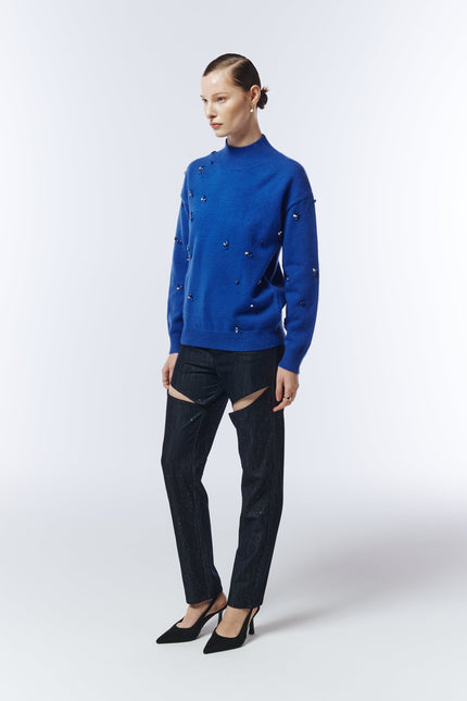 Side view of model in sapphire blue hand-stitched gemstone jumper by Sour Figs.
