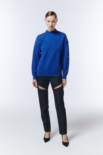Model wearing the Sour Figs sapphire blue gemstone jumper paired with dark cut-out trousers.