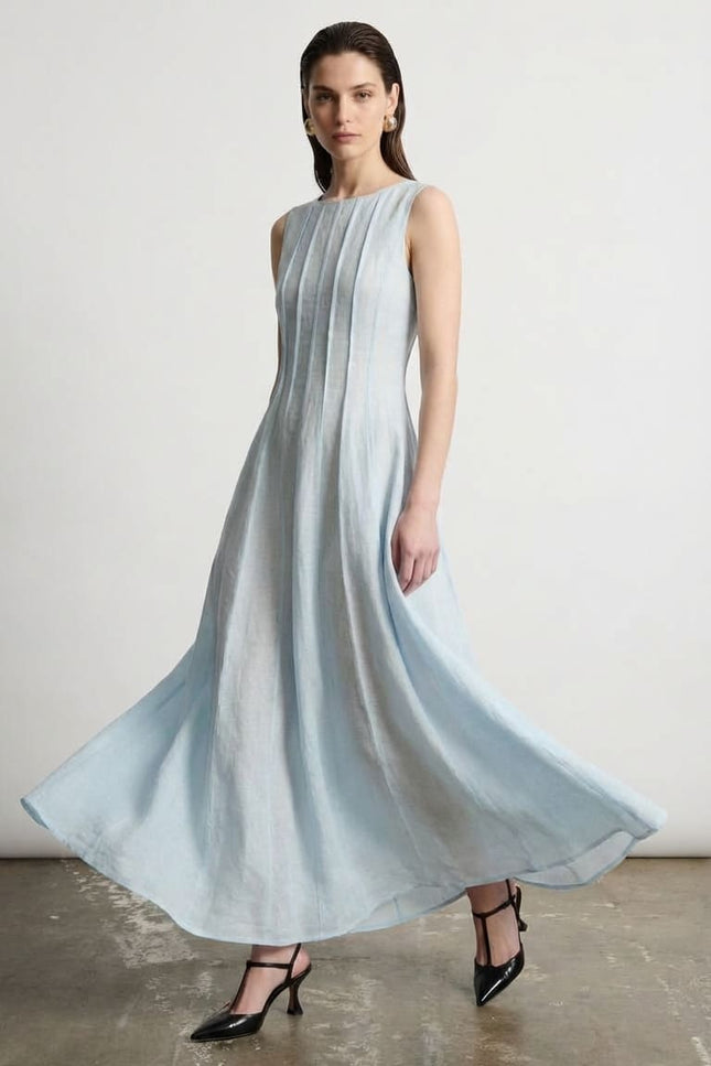 Woman wearing a light blue dress standing against a plain background