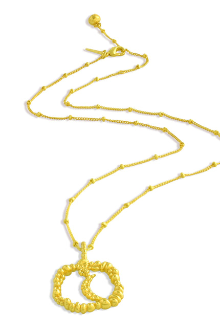 Gold necklace with a moon shaped Granulated pendant on a white background