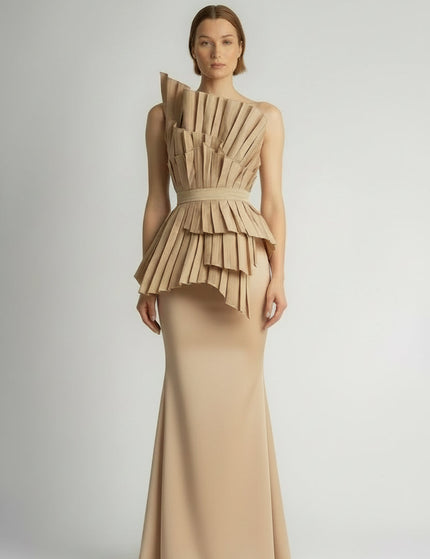 Model wearing a unique dress with a layered beige top and lace skirt on a plain background