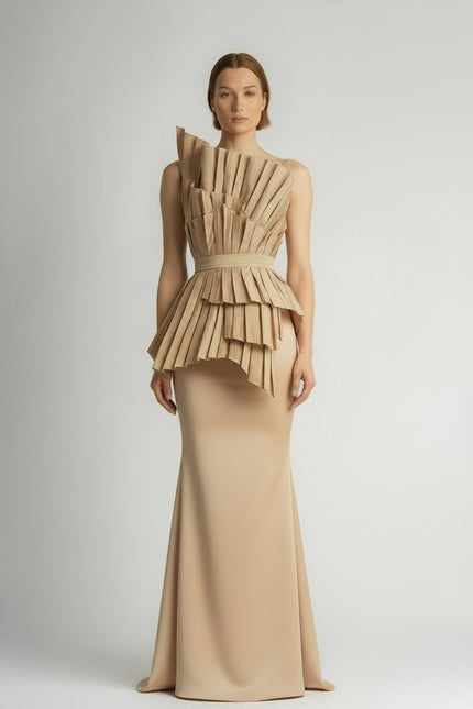 Model wearing a unique dress with a layered beige top and lace skirt on a plain background
