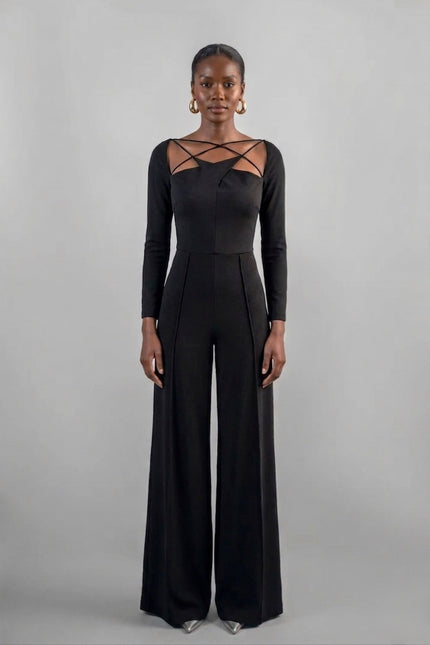 Woman wearing a black jumpsuit with long sleeves and lace-up details on a gray background