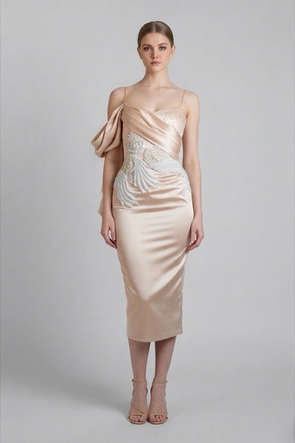 Woman wearing a beige evening gown with floral details on a gray background