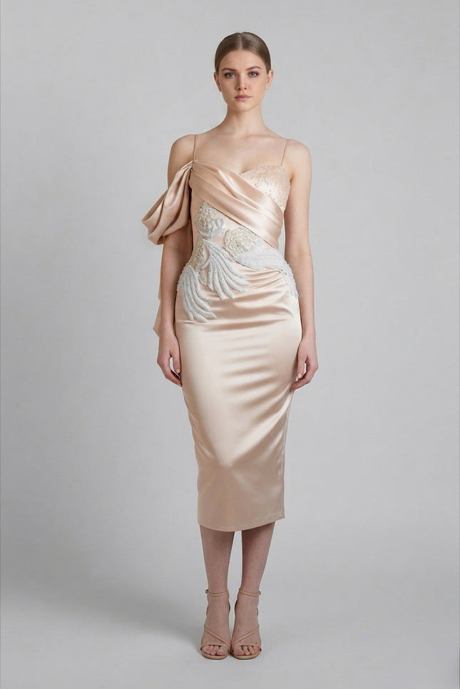 Woman wearing a beige evening gown with floral details on a gray background