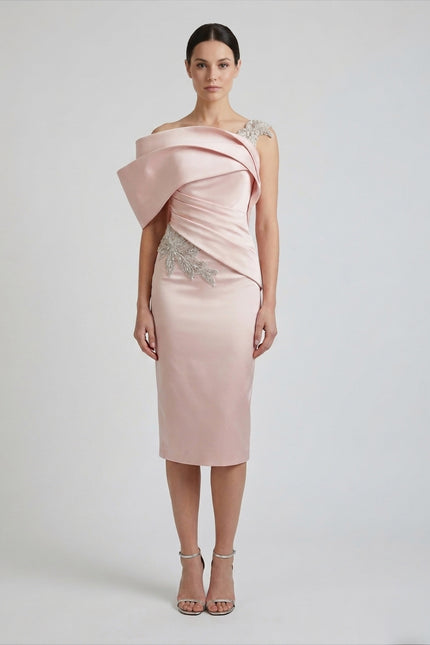 Woman wearing a pink off-shoulder dress with embellishments on a white background