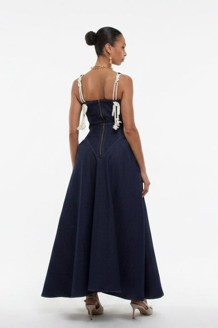 Woman wearing a navy blue dress with white straps on a white background
