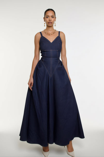 Woman wearing a navy blue dress with a white background