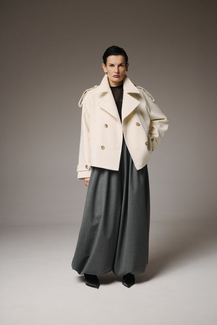 This Wool Short Coat defines effortless elegance with a modern, sculptural edge.

Crafted from 95% fine wool, it offers natural warmth and structure while maintaining a light, fluid silhouette. The crisp white tone conveys purity and quiet sophistication, making it a statement of minimalist luxury.