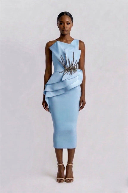 Woman wearing a light blue dress with a textured top on a white background