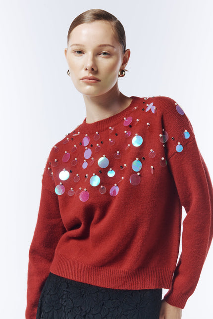 Close-up of iridescent sequin embellishments on SOUR FIGS red jumper.