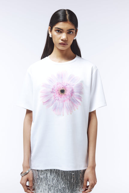 Model wearing white floral graphic T-shirt with pastel-toned bloom
