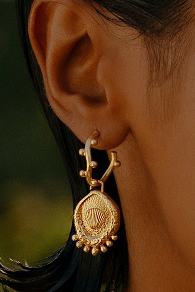 A close-up image of a woman's ear wearing Gold Plated Morsel Shell Earring By Arvino