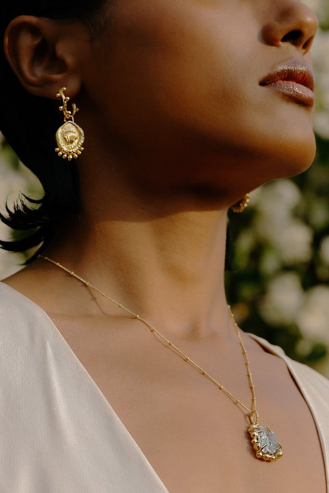 Model wearing Morsel Shell Earrings By arvino with a gold plated Pendant.
Premium Gold Plated Earrings By Arvino.