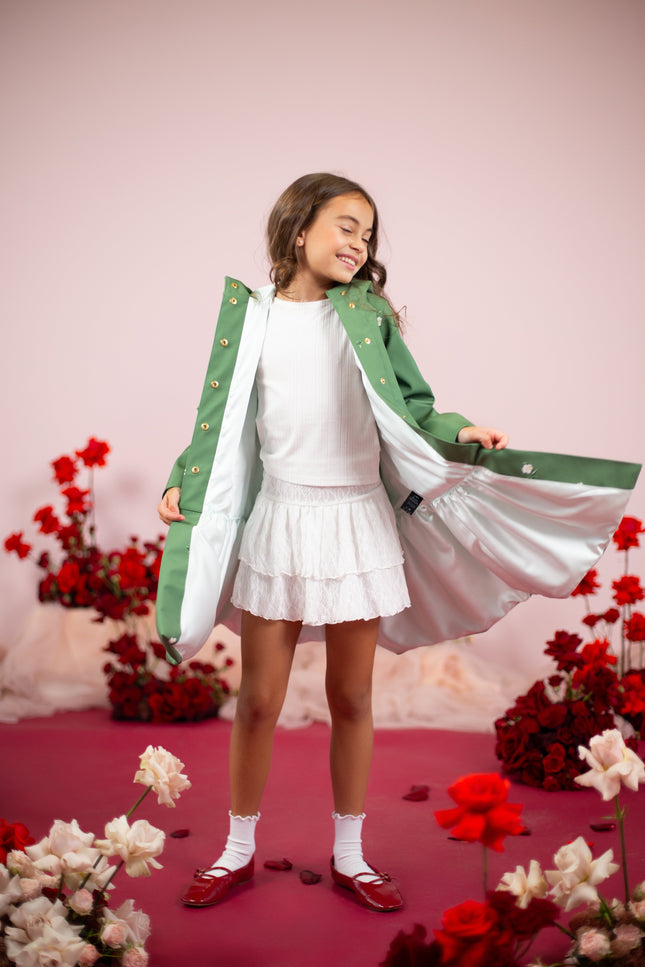 Close-up of the white floral print on a vibrant green coat with water-resistant material