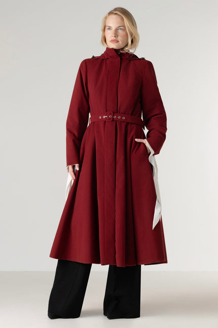 Full-length view of a women's deep red fit and flare winter coat in a rich maroon shade, featuring a fitted bodice, flared skirt, black Italian satin lining, and a matching belt.