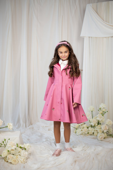 Young girl wearing a pink coat with a hood