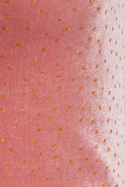 Close-up of the Sarvin Pink Velvet Polka Dot Dress, featuring a shiny texture with evenly spaced small gold dots—ideal for elegant evening occasions.