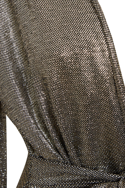 Close-up of Sarvin's Long Sleeve Sequin Wrap Dress, featuring metallic, shimmering fabric with a fine mesh pattern draped at the waist. The material reflects light beautifully, creating a textured effect perfect for evening wear.