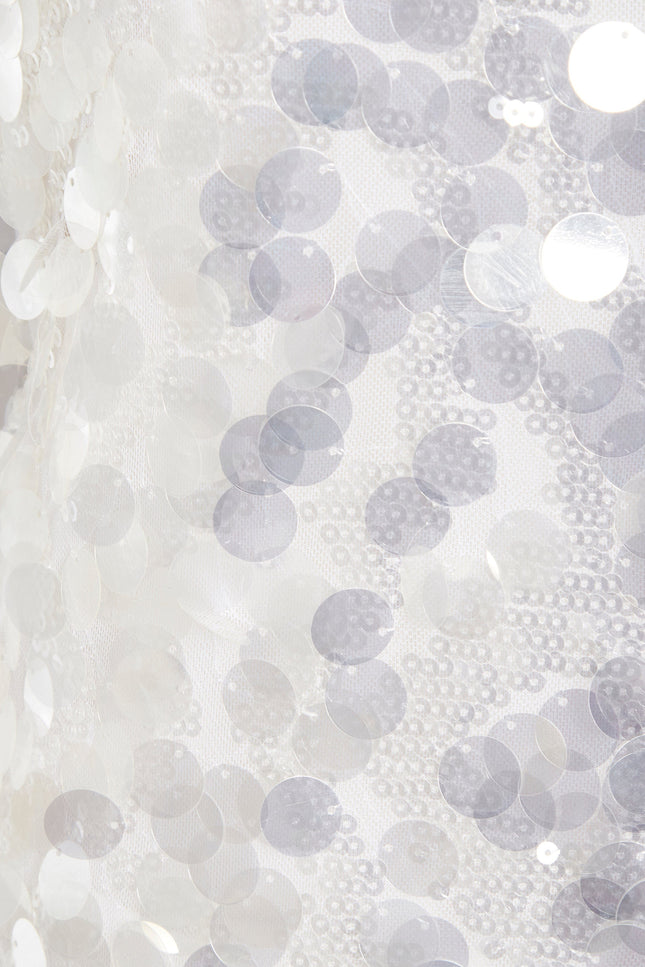 Close-up of shiny white sequins sewn onto sheer fabric, creating a textured, reflective look on the Sarvin White Sequin Backless Mini Dress—perfect for making a dazzling entrance.