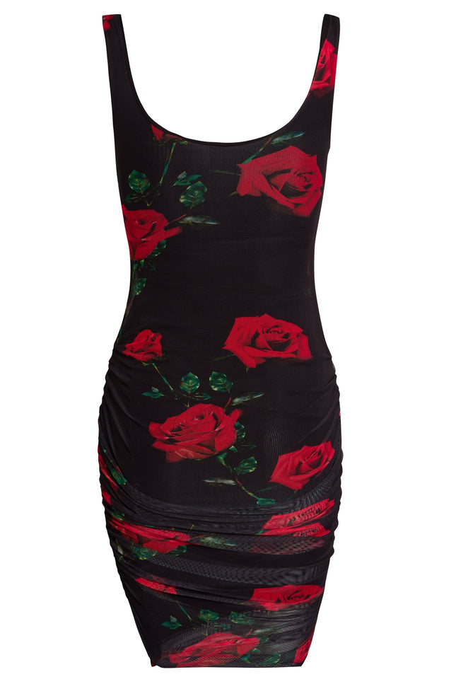 The Sarvin Ruched Bodycon Mini Dress is a sleeveless, form-fitting black mini dress with red rose and green leaf print, plus side ruching.