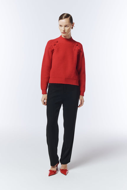 Model wearing SOUR FIGS Shoulder-Detail Bobble-Knit Jumper in Crimson Red with black trousers.