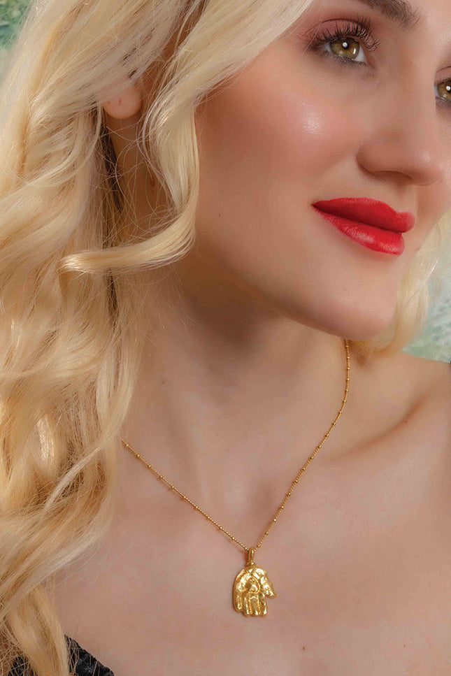 Model Wearing a gold plated Sculpted Hand Charm necklace by Arvion. Best Demi Fine Jewelry By Arvino