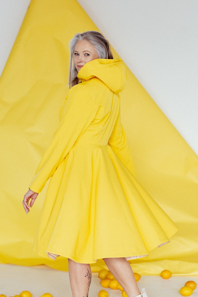 Back view of Yellow Sun coat – full-volume flared skirt with playful and elegant design.