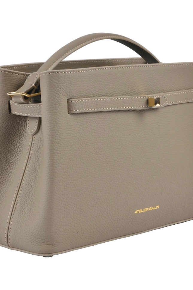 Beige atelier-galin-cube-lock-bag  handbag with gold accents on a white background